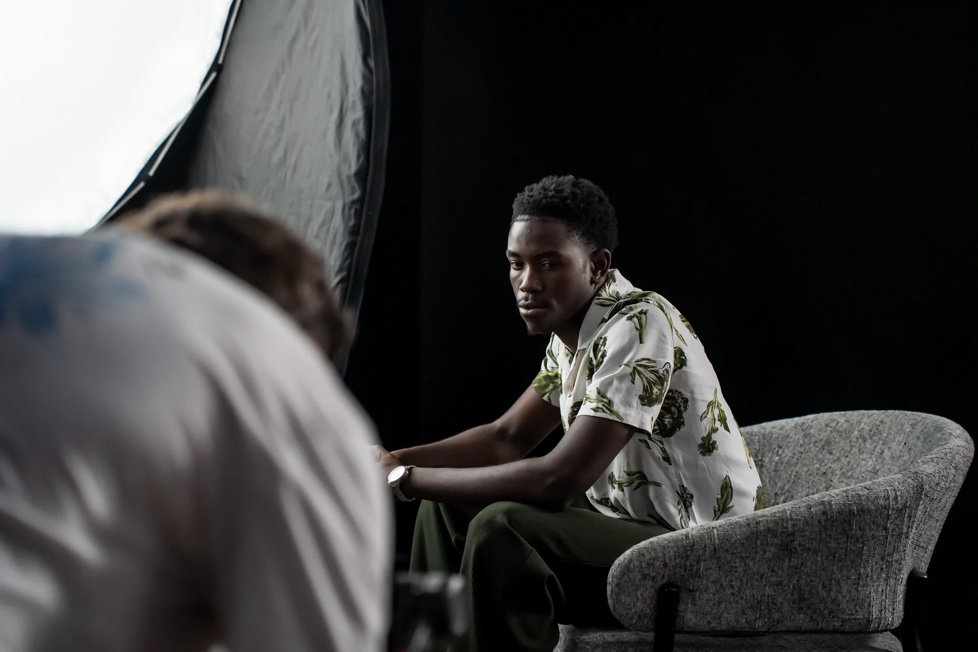 A seated subject framed during an intimate studio production setup